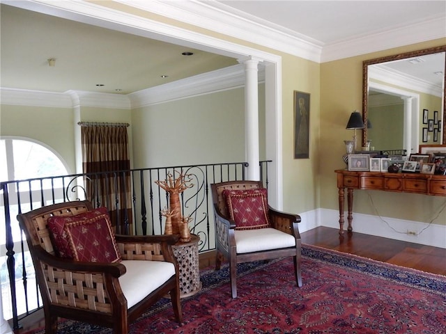 living area with hardwood / wood-style floors, ornate columns, and crown molding