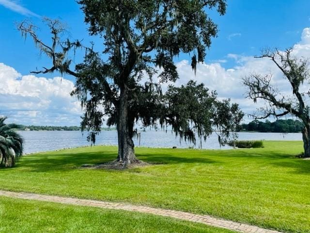 surrounding community featuring a lawn and a water view