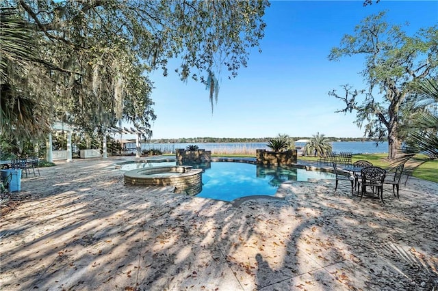 view of swimming pool with a water view and an in ground hot tub