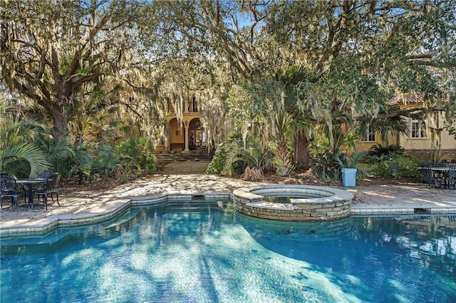 view of swimming pool featuring an in ground hot tub and a patio area