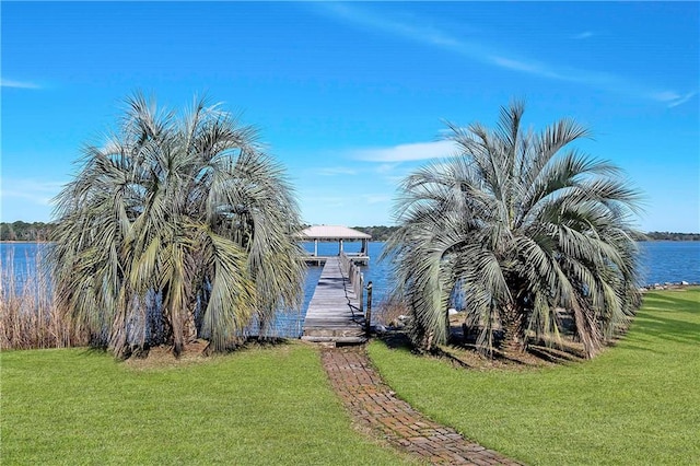 exterior space featuring a water view, a dock, and a lawn