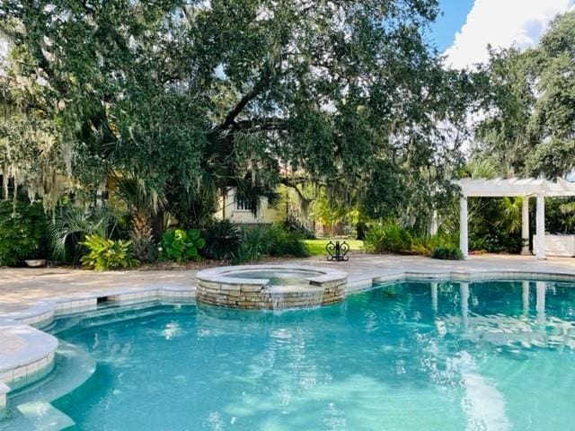 view of pool featuring an in ground hot tub