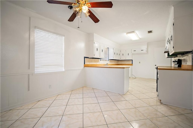 kitchen featuring range, white cabinets, ceiling fan, light tile patterned floors, and kitchen peninsula