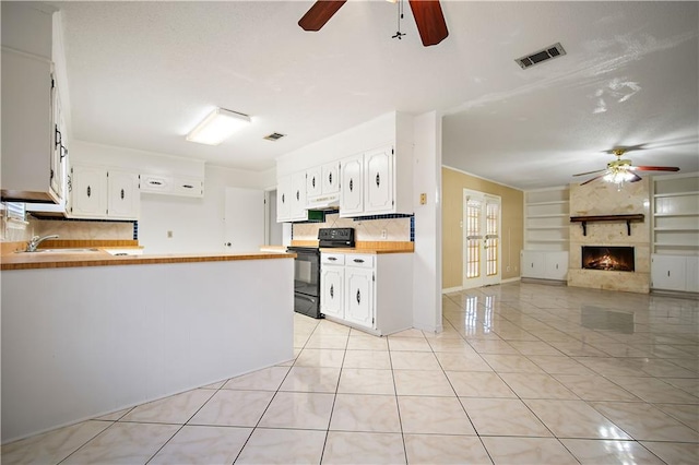 7183 Pine Barren Ct, Mobile, AL 36695 - kitchen with black range with electric cooktop, ceiling fan, built in shelves, a peninsula, and under cabinet range hood