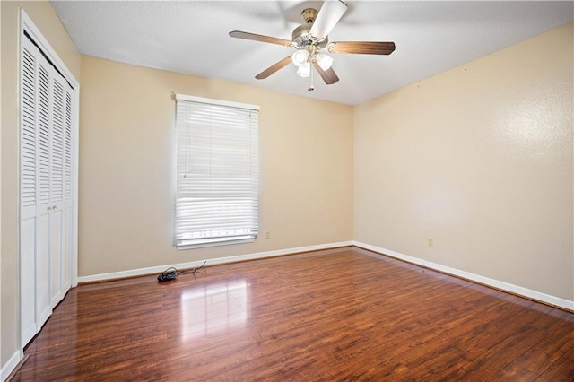 unfurnished bedroom with ceiling fan, a closet, and dark hardwood / wood-style floors