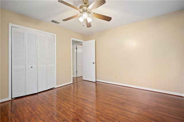 unfurnished bedroom with ceiling fan, dark hardwood / wood-style flooring, and a closet