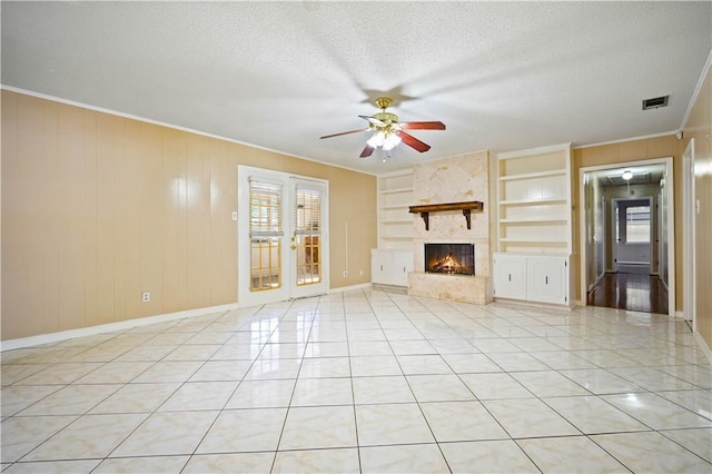 7183 Pine Barren Ct, Mobile, AL 36695 - unfurnished living room featuring built in features, a ceiling fan, a fireplace, ornamental molding, and a textured ceiling