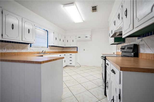 kitchen featuring wooden counters, range, backsplash, and white cabinetry