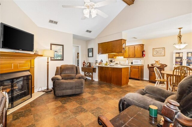 living room featuring lofted ceiling with beams, dark tile patterned flooring, and ceiling fan