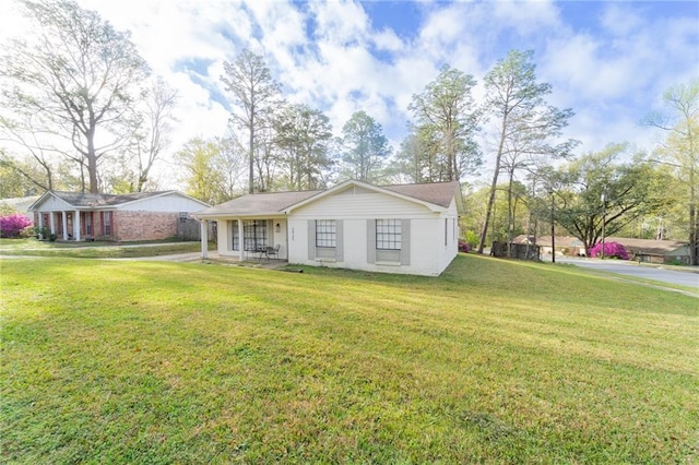 ranch-style house featuring a front yard and covered porch