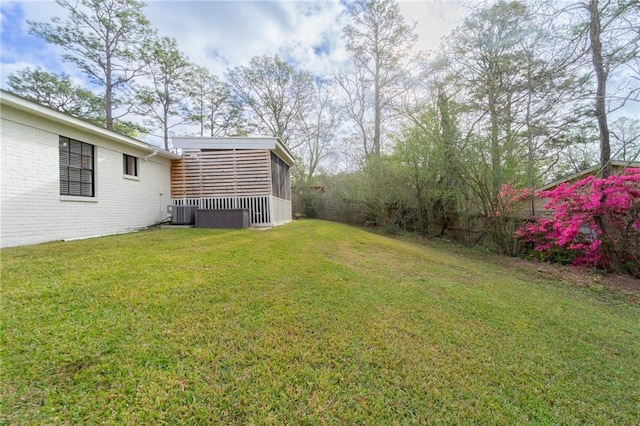 view of yard featuring central AC unit, fence, and a sunroom