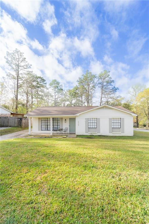 view of front of home featuring concrete driveway, a front yard, and fence