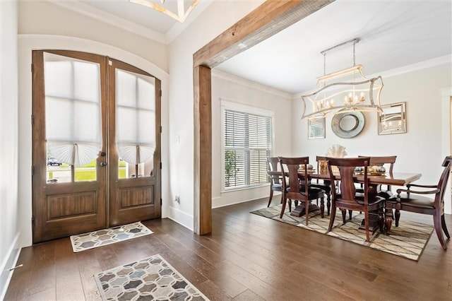 entrance foyer with french doors, an inviting chandelier, a wealth of natural light, and dark wood-type flooring