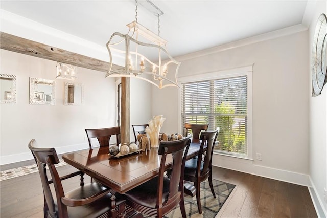 dining space with dark wood-type flooring, a chandelier, and ornamental molding