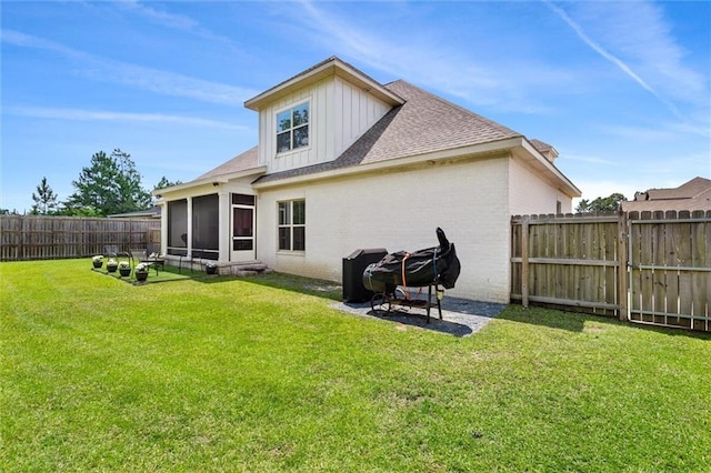 rear view of house with a lawn and a sunroom