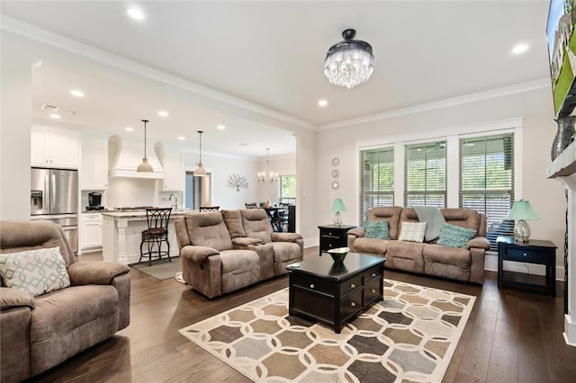 living room with crown molding, hardwood / wood-style floors, and a notable chandelier