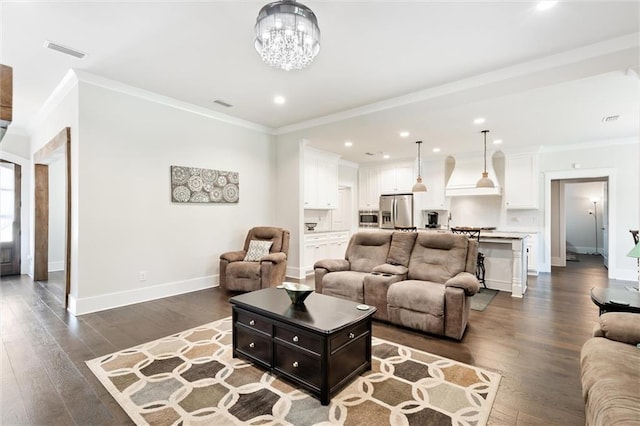 living room with dark hardwood / wood-style flooring, ornamental molding, and a chandelier