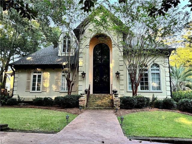 view of front of house with a front lawn and roof with shingles