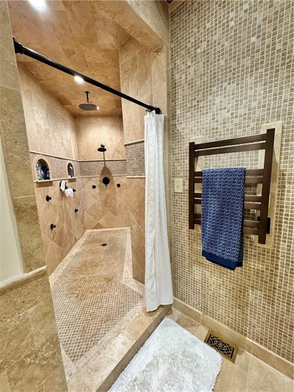 bathroom with tile walls and a shower with shower curtain