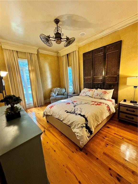 bedroom with ceiling fan, light wood-type flooring, and ornamental molding