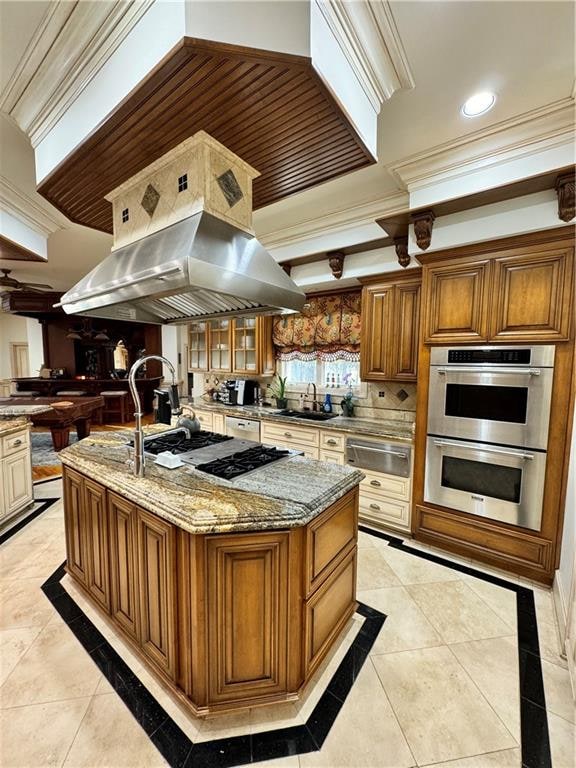 kitchen featuring appliances with stainless steel finishes, crown molding, sink, a large island with sink, and light tile patterned floors