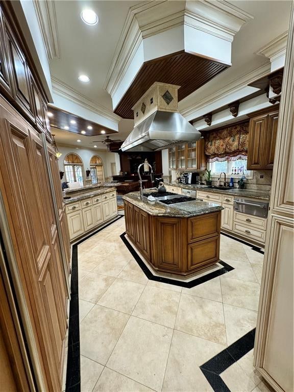 kitchen with a center island with sink, ventilation hood, ornamental molding, and sink