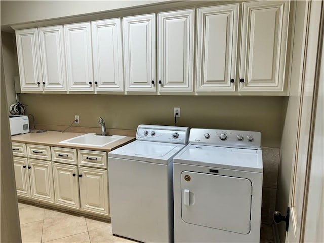 laundry room featuring cabinets, washing machine and dryer, light tile patterned flooring, and sink