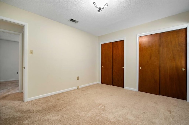 4205 Chesterfield Dr N, Mobile, AL 36618 - unfurnished bedroom featuring carpet floors, multiple closets, a textured ceiling, and baseboards