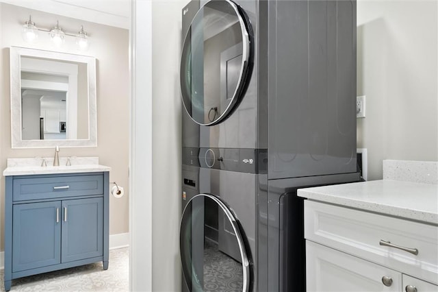 clothes washing area with stacked washer / drying machine and sink