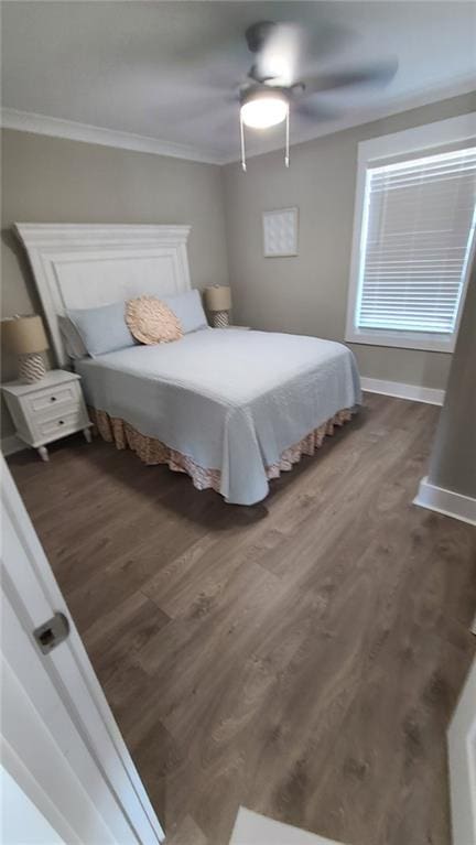 bedroom featuring ceiling fan, dark hardwood / wood-style flooring, and ornamental molding