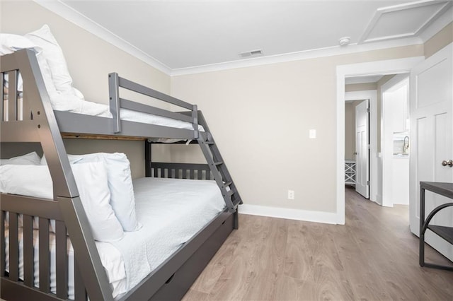 bedroom featuring light hardwood / wood-style flooring and ornamental molding