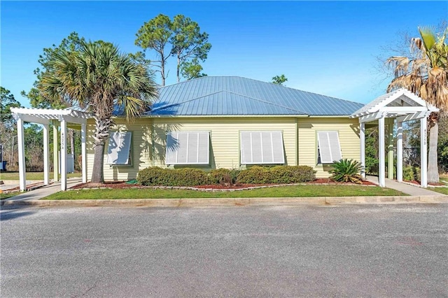 view of front of property featuring a pergola and metal roof