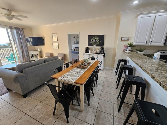 dining area with crown molding, light tile patterned floors, and ceiling fan