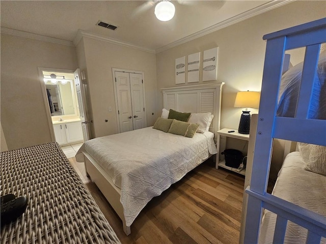 bedroom with connected bathroom, ornamental molding, a closet, hardwood / wood-style flooring, and ceiling fan