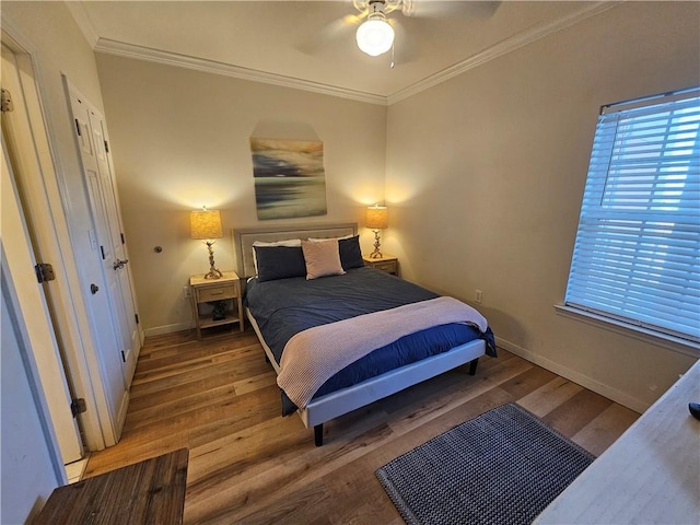 bedroom featuring crown molding, wood-type flooring, and ceiling fan