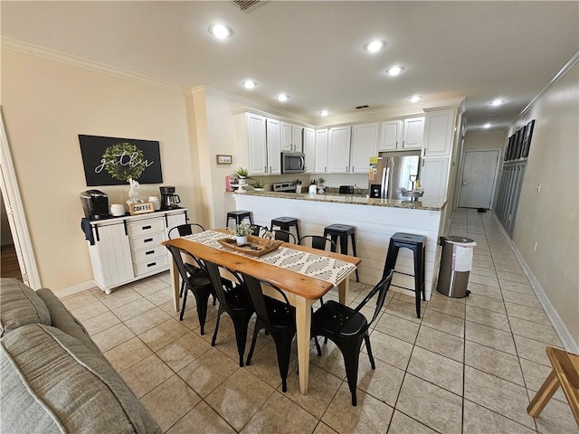 dining area with light tile patterned floors and crown molding