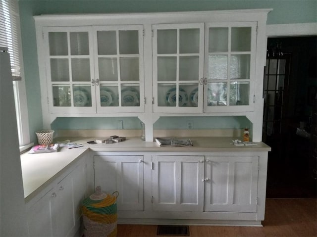 bar featuring dark hardwood / wood-style floors and white cabinets