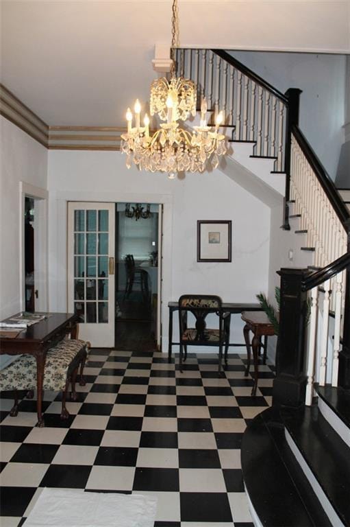 interior space with ornamental molding, dark tile floors, and a chandelier