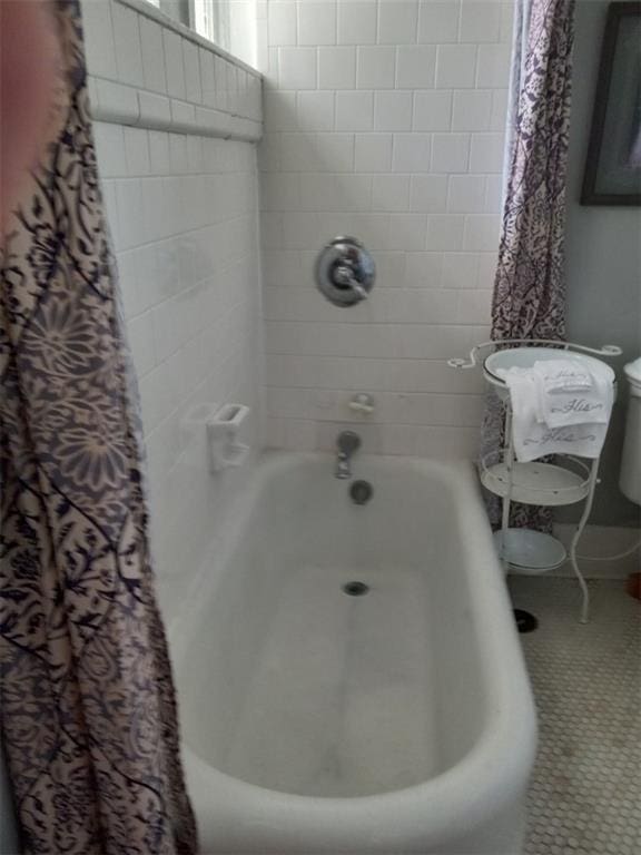 bathroom featuring shower / bath combo with shower curtain and tile floors