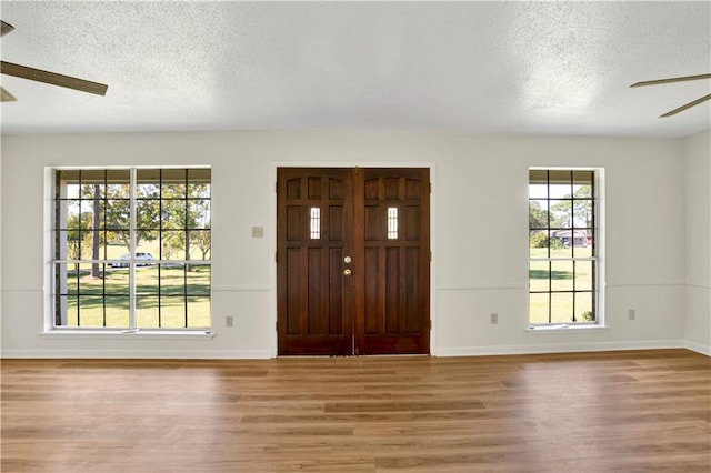 entryway with ceiling fan, hardwood / wood-style floors, and a textured ceiling