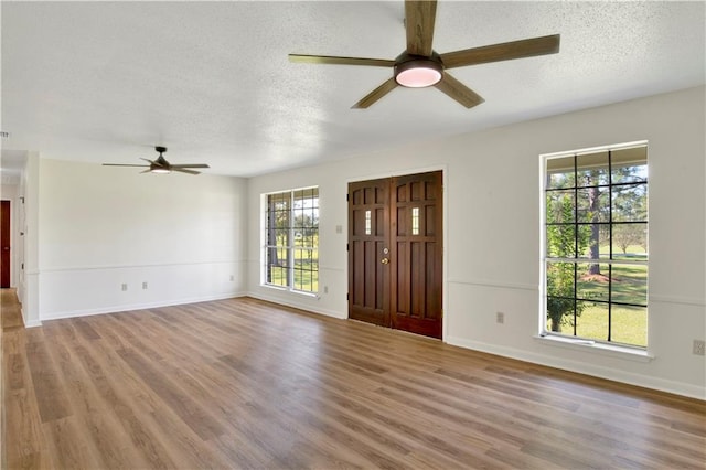 unfurnished living room with ceiling fan, wood-type flooring, and a textured ceiling