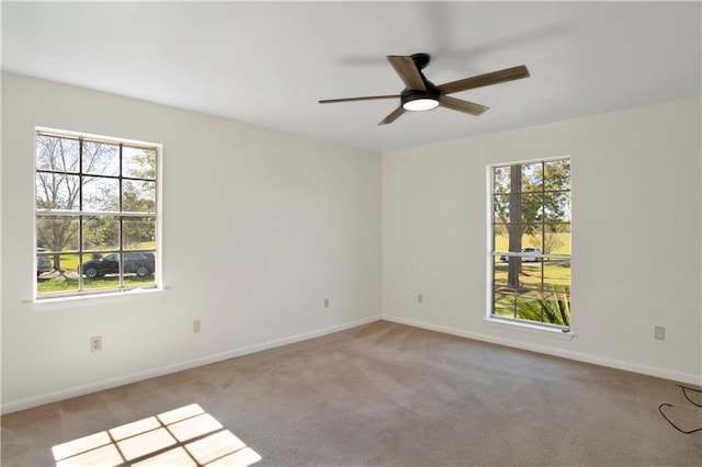 unfurnished room featuring light carpet, a healthy amount of sunlight, and ceiling fan