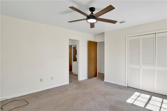 unfurnished bedroom with light carpet, ceiling fan, and a closet