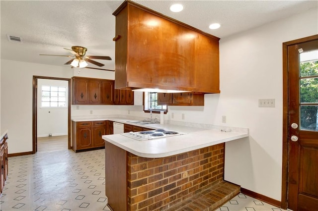 kitchen featuring white appliances, kitchen peninsula, ceiling fan, and a textured ceiling