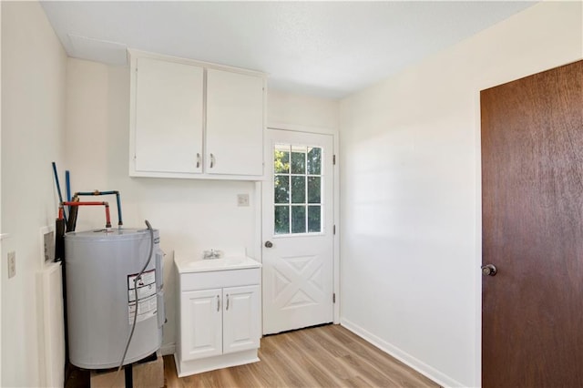 interior space featuring light wood-type flooring, water heater, and cabinets