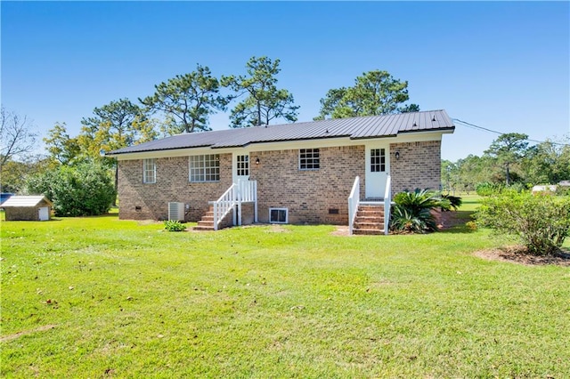 back of property with central AC and a lawn