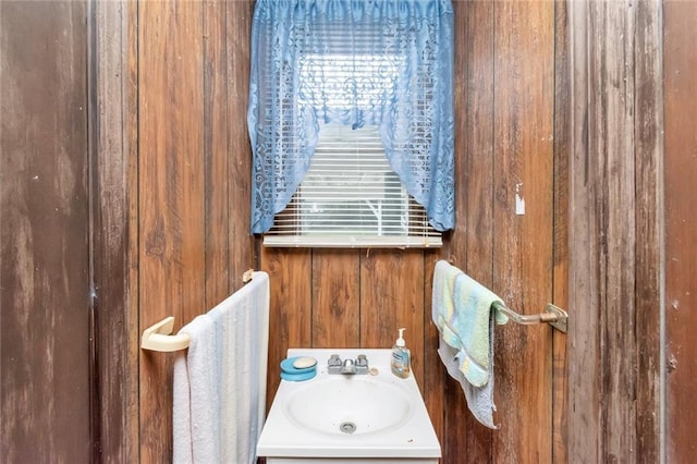 bathroom with wooden walls and sink