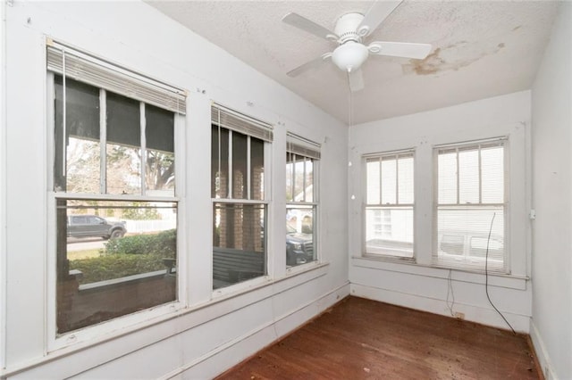 unfurnished sunroom featuring ceiling fan