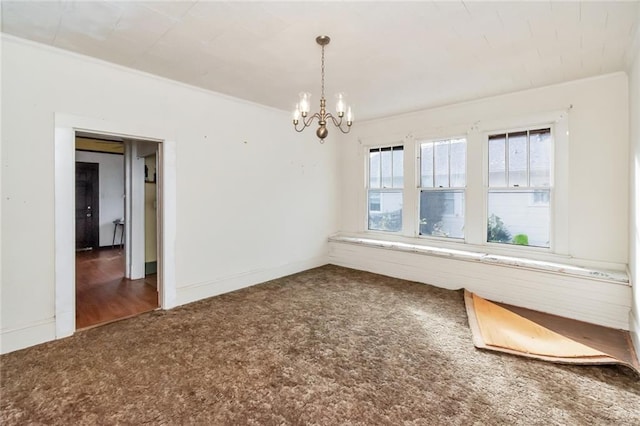 carpeted empty room with a chandelier