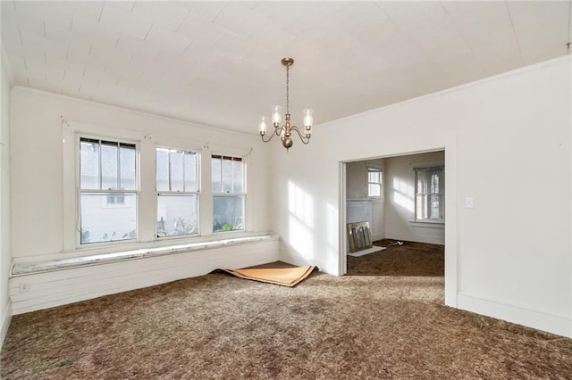 spare room with plenty of natural light, carpet floors, and an inviting chandelier